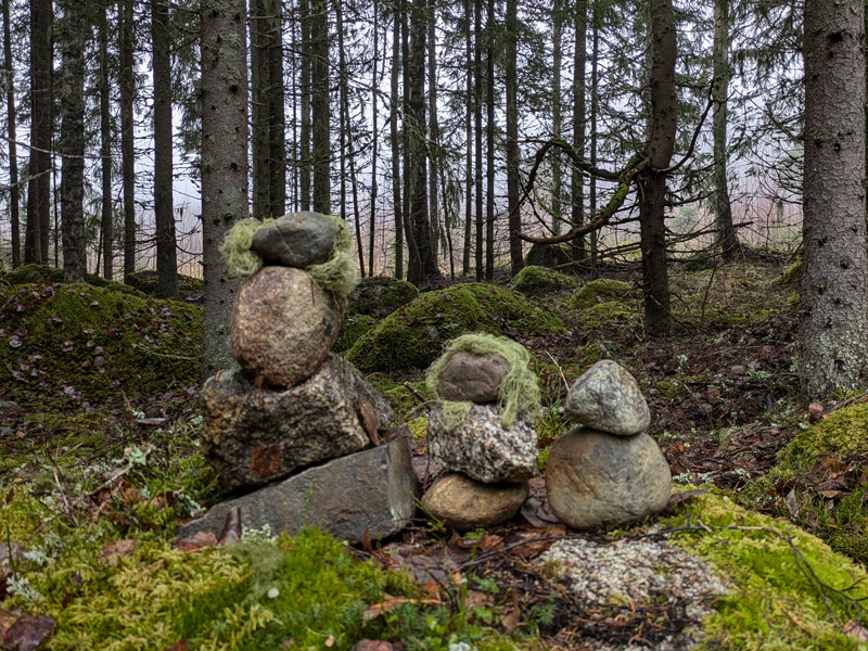 Luonnonkivistä ja -materiaaleista pinotut perheenjäsenet.
